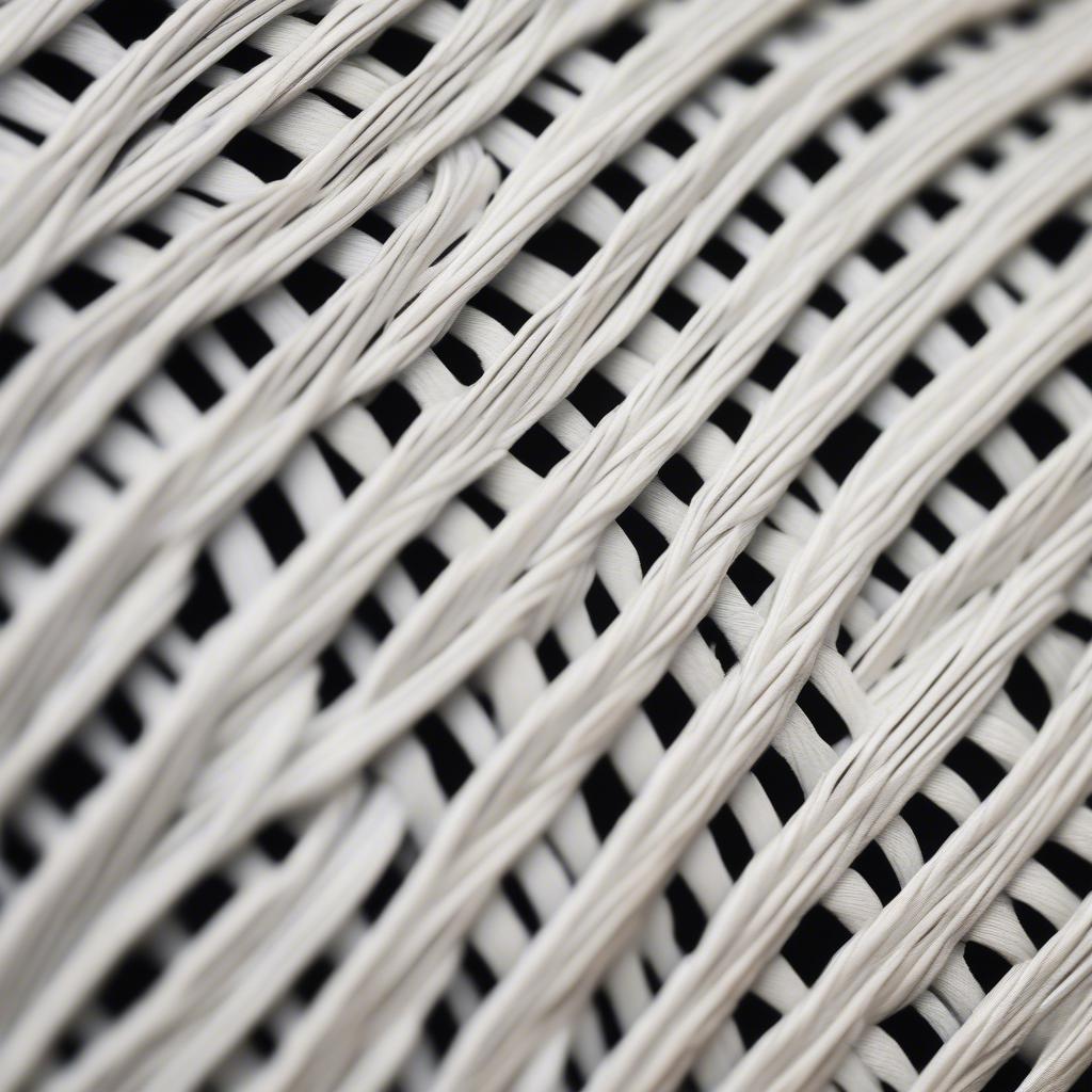 Close up detail of the intricate weave of a white wicker chest, highlighting the craftsmanship and texture.