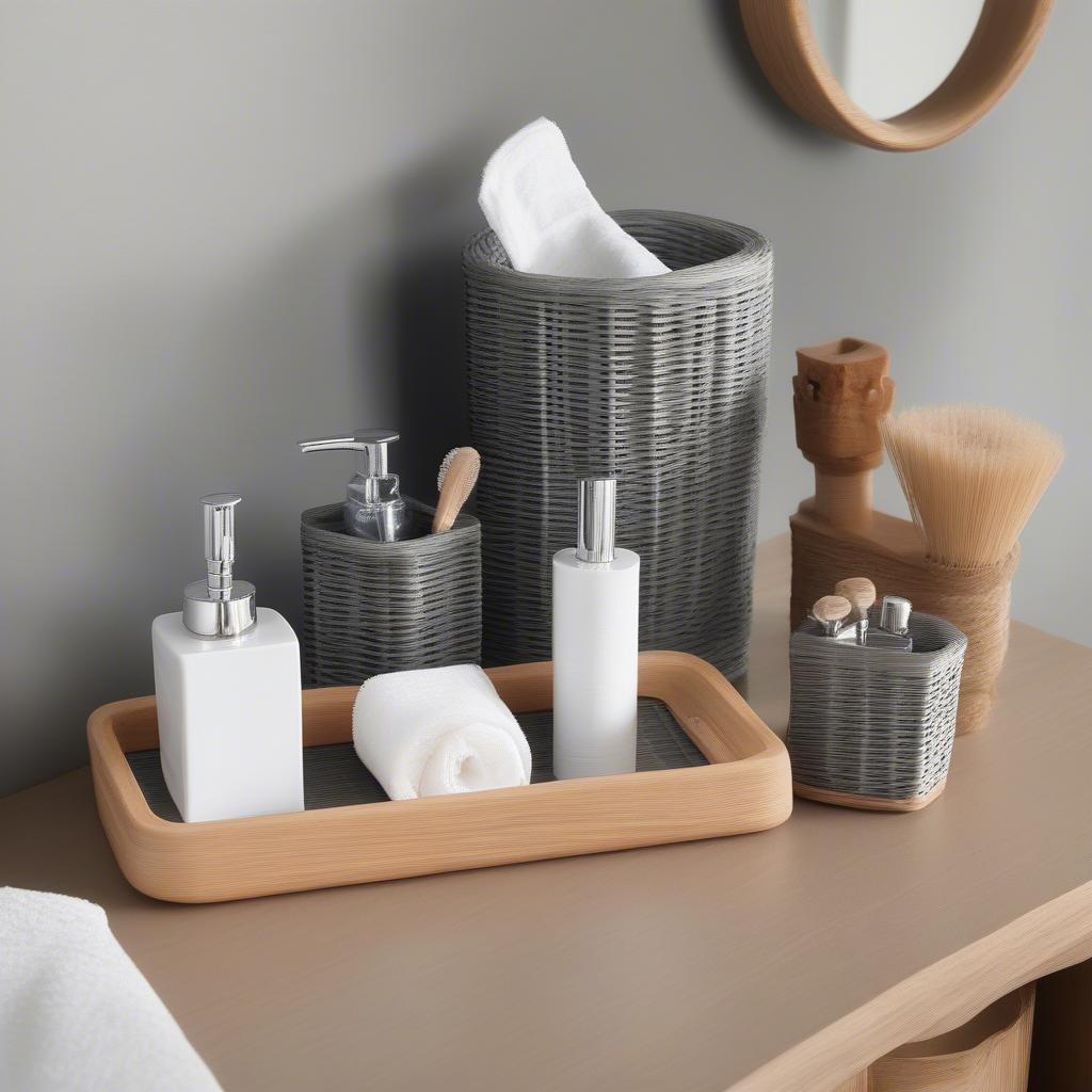 Set of grey wicker bathroom accessories including toilet roll holder, hand towel holder, and wastebasket.