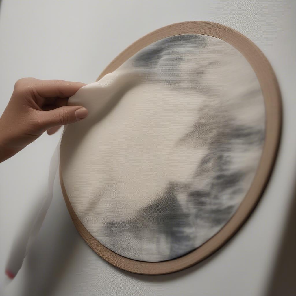 A person gently cleaning a printed canvas picture with a soft cloth