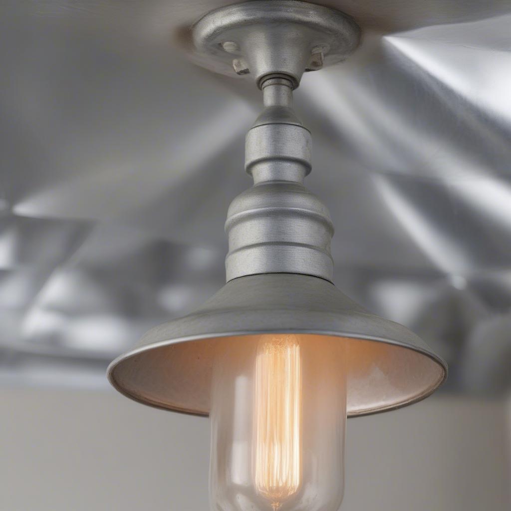 Close-up of a galvanized metal light fixture showing the textured surface and silvery finish