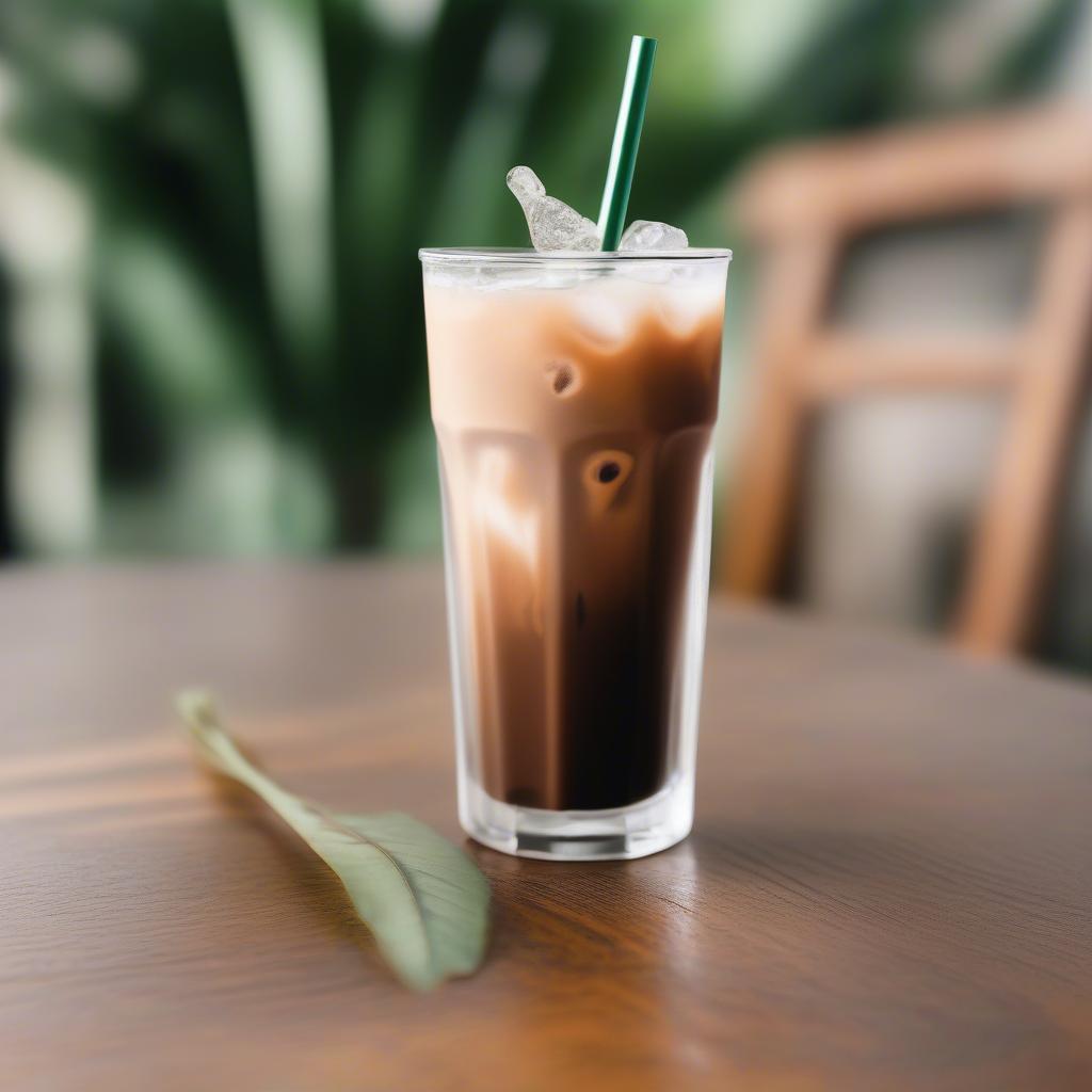 Small tumbler with straw filled with iced coffee