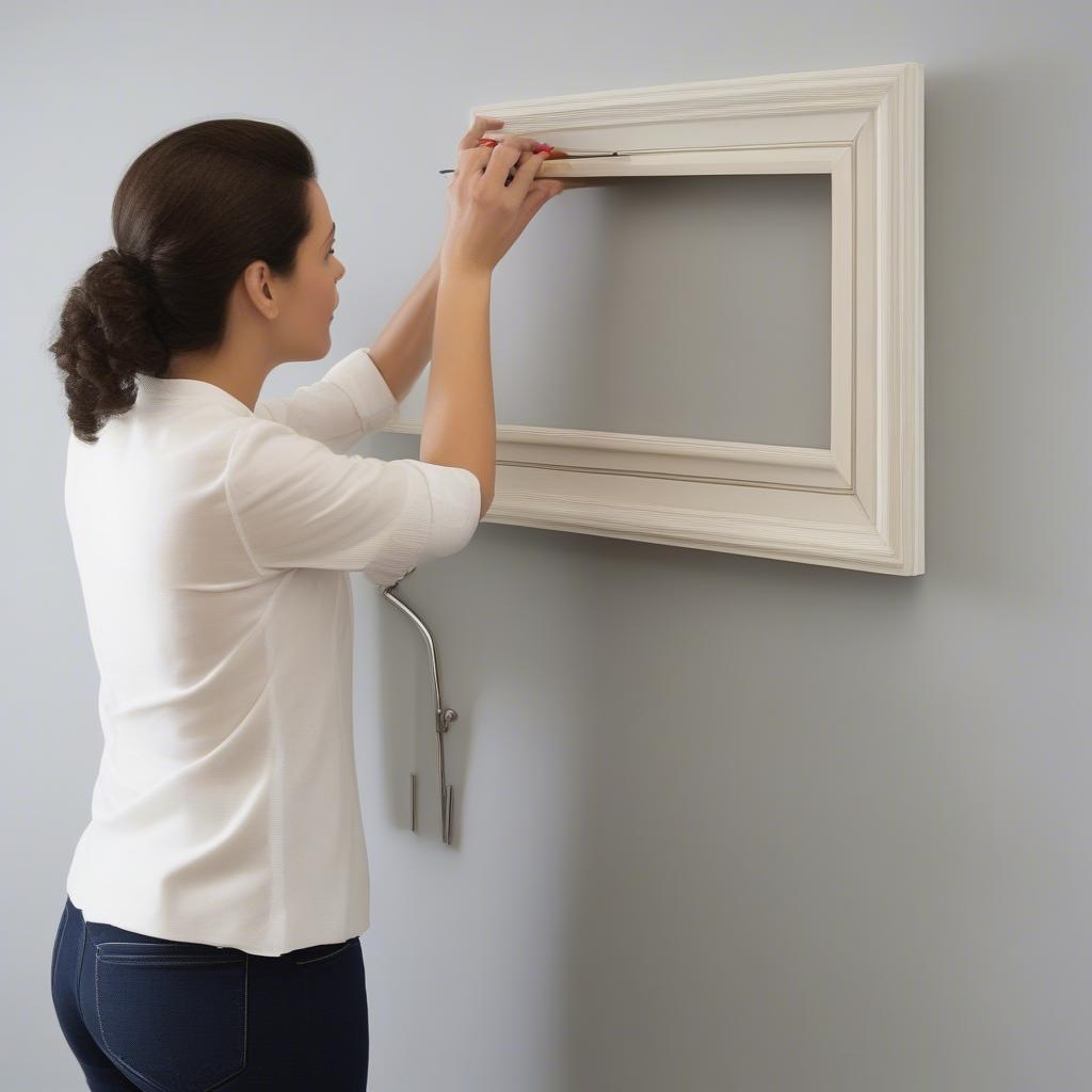 Woman Hanging a Picture Frame